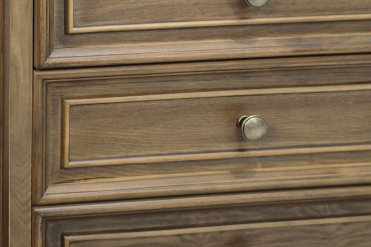 Close-up of the Light Brown finish: framed drawer fronts with open ash grain and a round antique-brass-tone knob
