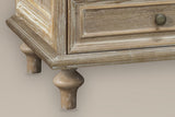 Close-up of the stepped plinth and two turned pine legs of the Osimo nightstand in Natural White