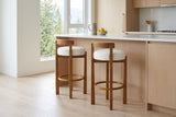 Two Otricoli bar stools at a white-oak kitchen island in a bright Vancouver condo with a window onto cedars and mountains