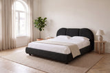 Padula bed in black made up with white linen, in a bright bedroom with an arched window and a fiddle-leaf fig