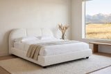 Padula bed in a bright bedroom with a wide window onto grassland and the Rocky Mountains