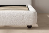 Close-up of the rounded padded rail and a dark ball foot on an oak floor
