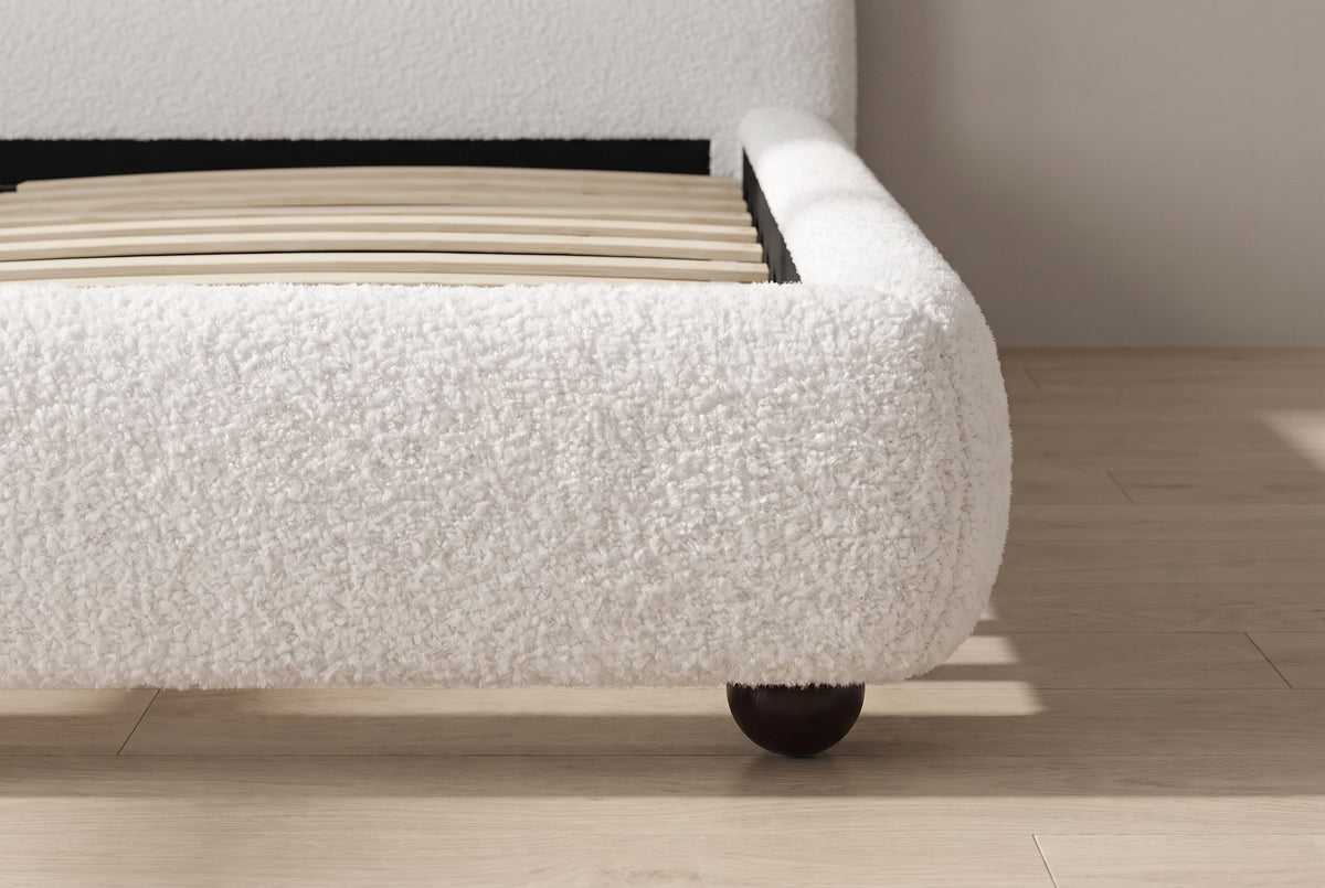 Close-up of the rounded padded rail and a dark ball foot on an oak floor