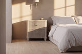 Palestrina nightstand in Beige beside a low bed in a plaster bedroom at golden hour