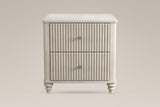 Palestrina nightstand in Beige, straight front view: two fluted drawers with round brushed-silver knobs, rounded corner posts