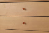 Close-up of two Parma drawer fronts with their copper-tone ball knobs and the grooved surround above