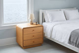Parma nightstand beside a bed in a blue-grey Halifax bedroom with a harbour view