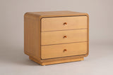 Parma rounded 3-drawer nightstand in Natural, three-quarter view on a warm grey studio backdrop