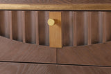 Close-up of the Pavia top drawer: carved flutes cut along an arc, the gold-tone plate and knob