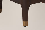 Close-up of a Pavia corner post in Dark Brown running into a tapered leg with a gold-tone cap and a floor glide