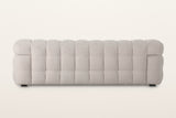 Back of the Pergola sofa in Beige on a warm white studio backdrop: the back is puffed in rows of rounded channels too