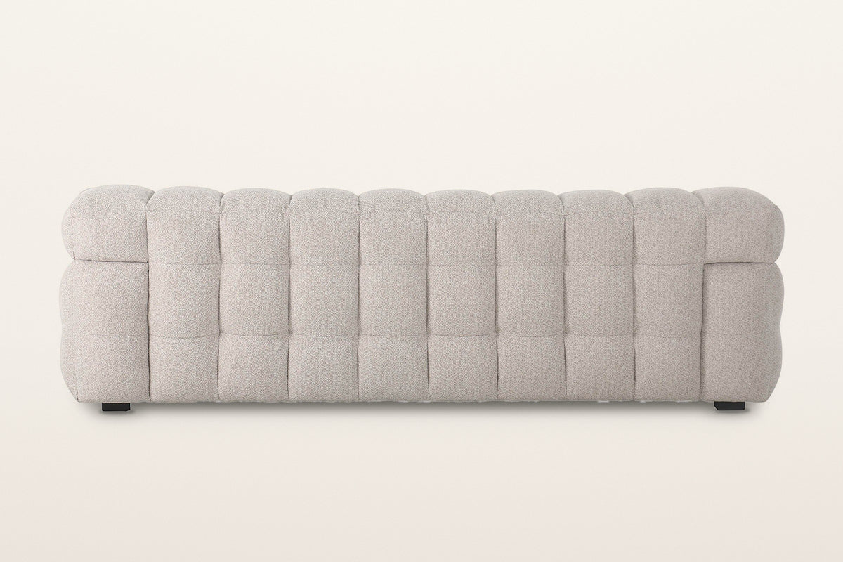 Back of the Pergola sofa in Beige on a warm white studio backdrop: the back is puffed in rows of rounded channels too