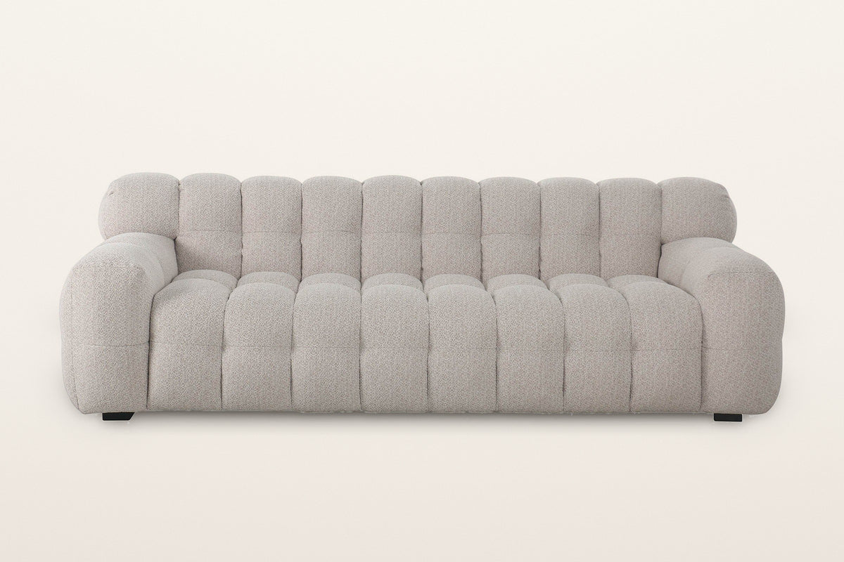 Pergola sofa in Beige, straight front view on a warm white studio backdrop: ten channels across the back and eight across