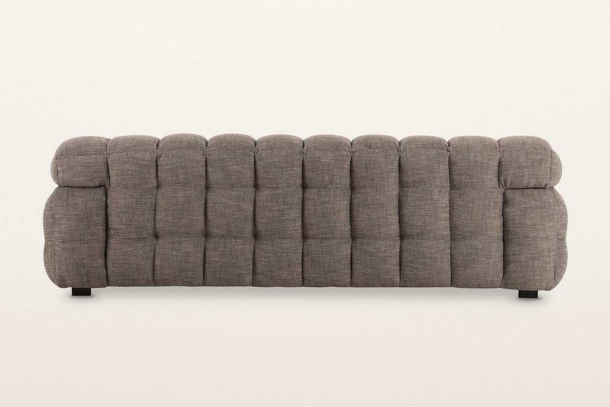 Back of the Pergola sofa in Brown on a warm white studio backdrop: the back is puffed in rows of rounded channels too