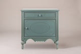 Perugia nightstand in Aged Blue, straight front view: one drawer over one door with a routed oval, four turned legs