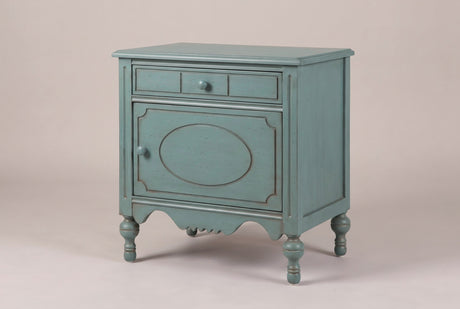 Perugia oval-panel nightstand in Aged Blue, three-quarter view on a warm grey studio backdrop