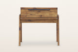 Pescasseroli end table in Brown, front view on a warm white studio backdrop: the drawer front of short acacia pieces with one black bar pull on its top edge