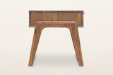 Pescasseroli end table from the side: the bent-wood frame with rounded inside corners standing outside the acacia case, two splayed legs