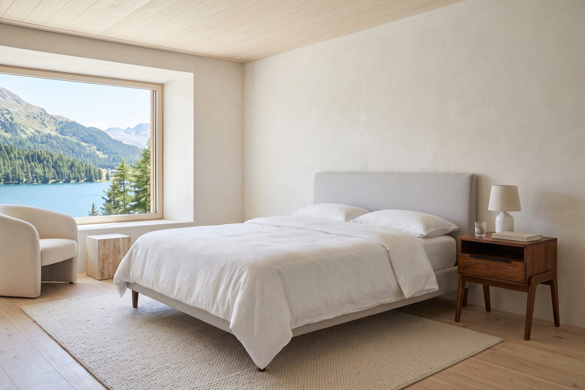 Pescasseroli nightstand in Brown acacia beside a grey upholstered bed in a bedroom in a St. Moritz chalet, with lime plaster