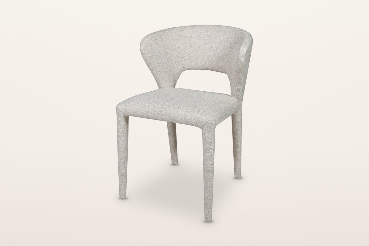 Petralia dining chair in Beige tweed, three-quarter view on a warm white studio backdrop