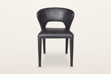Petralia dining chair in Black leather, straight front view on a warm white studio backdrop: the open window between the seat
