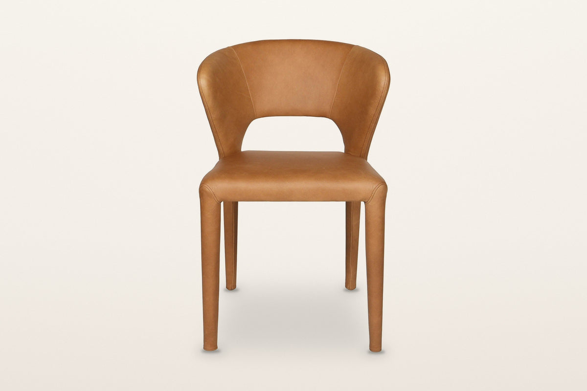 Petralia dining chair in Brown leather, straight front view on a warm white studio backdrop: the open window between the seat