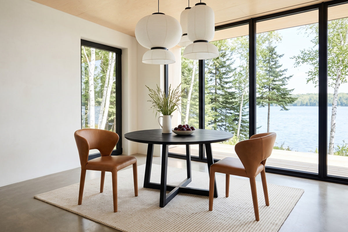 Two Petralia dining chairs in Brown leather seen from above at a round black ash table in a Waskesiu lake house