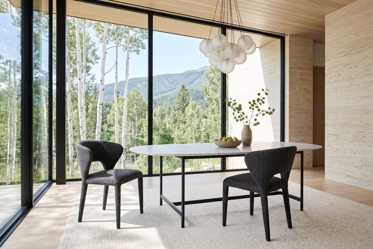Two Petralia dining chairs in Dark Grey at an oval marble table in a Kimberley mountain house