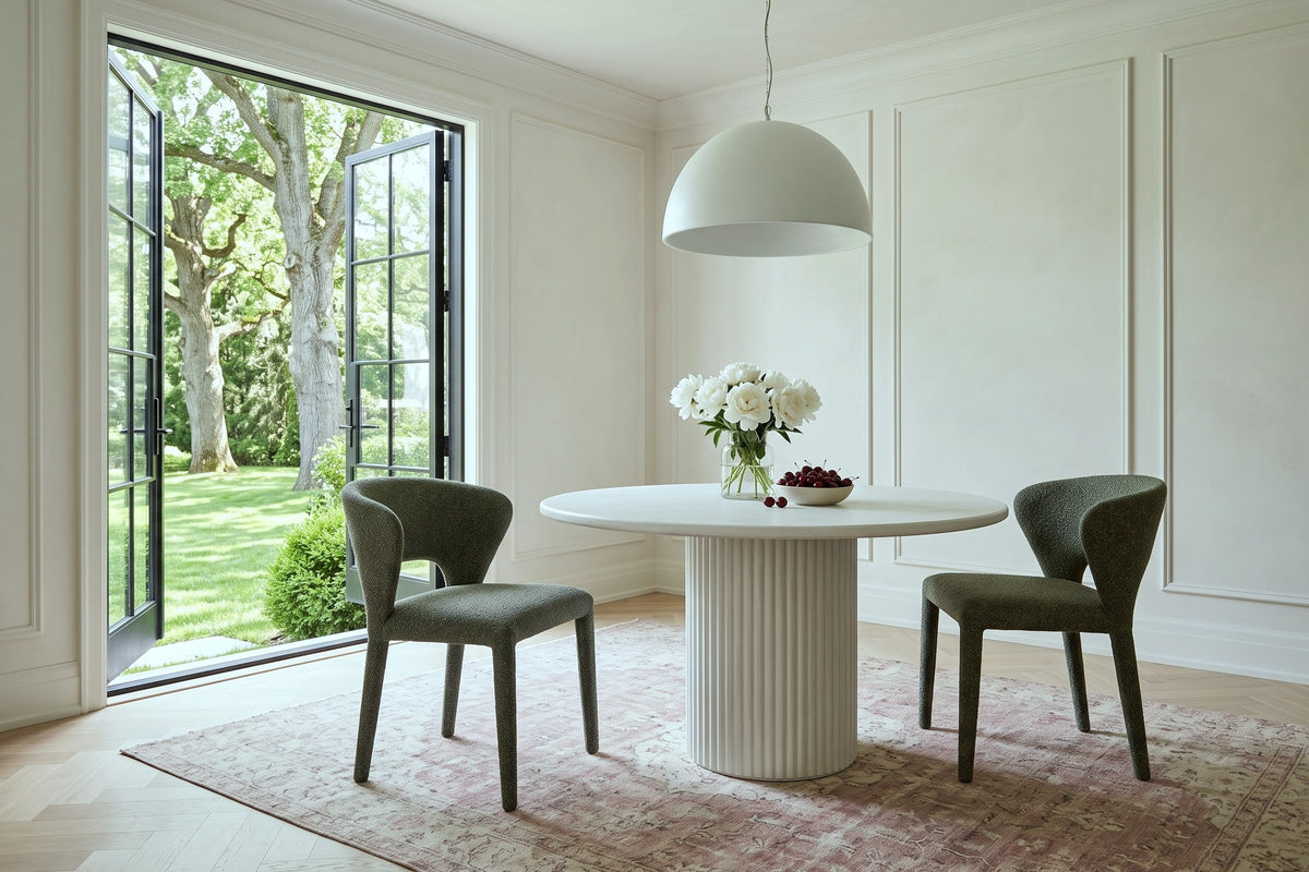 Two Petralia dining chairs in Green at a fluted plaster pedestal table in a Cobourg garden house