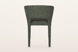 Back of the Petralia dining chair in Green on a warm white studio backdrop: a smooth wrapped shell with a low slot above