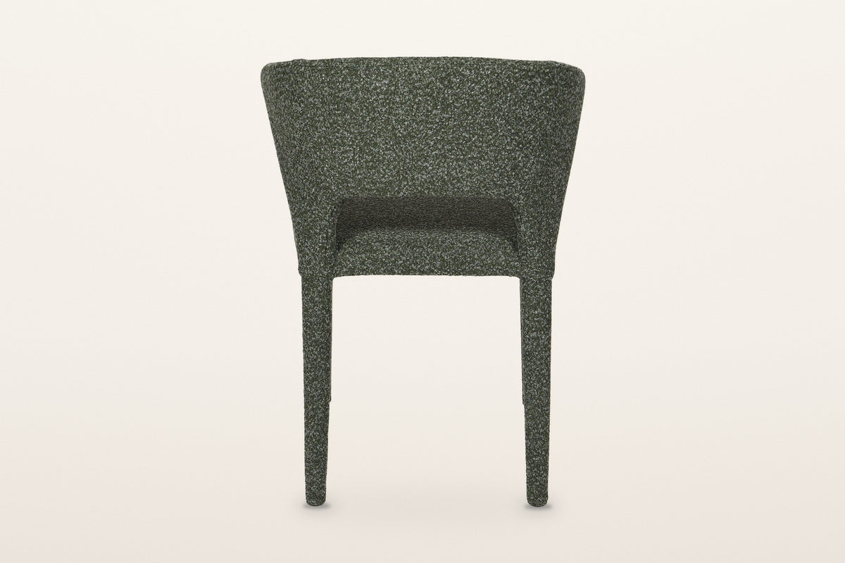 Back of the Petralia dining chair in Green on a warm white studio backdrop: a smooth wrapped shell with a low slot above