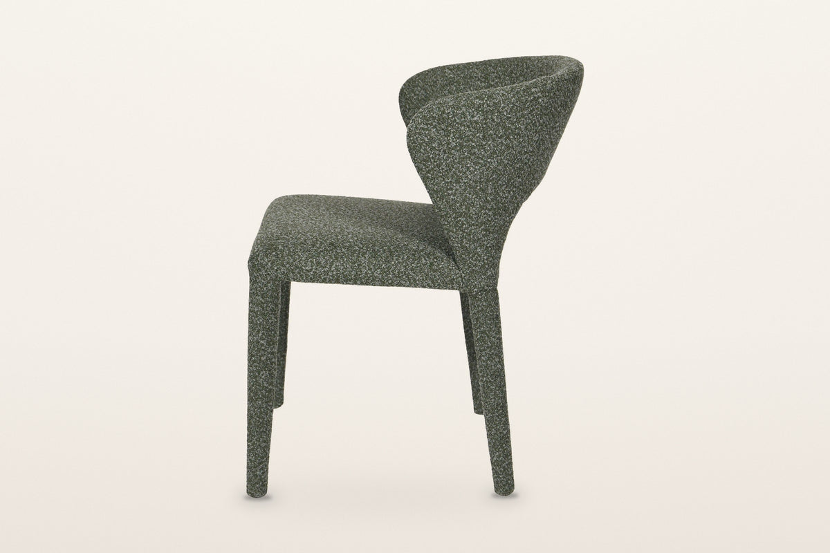 Petralia dining chair in Green, side view on a warm white studio backdrop: the back leans back and the rear legs rake out