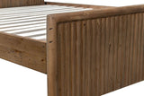 Close-up of the Pettorano footboard corner: the round top rail curving down into a round corner post above the reeded panel