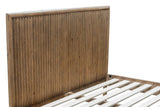 Close-up of the Pettorano headboard: narrow vertical rounded reeds inside a thick round frame, the side rail and slats below