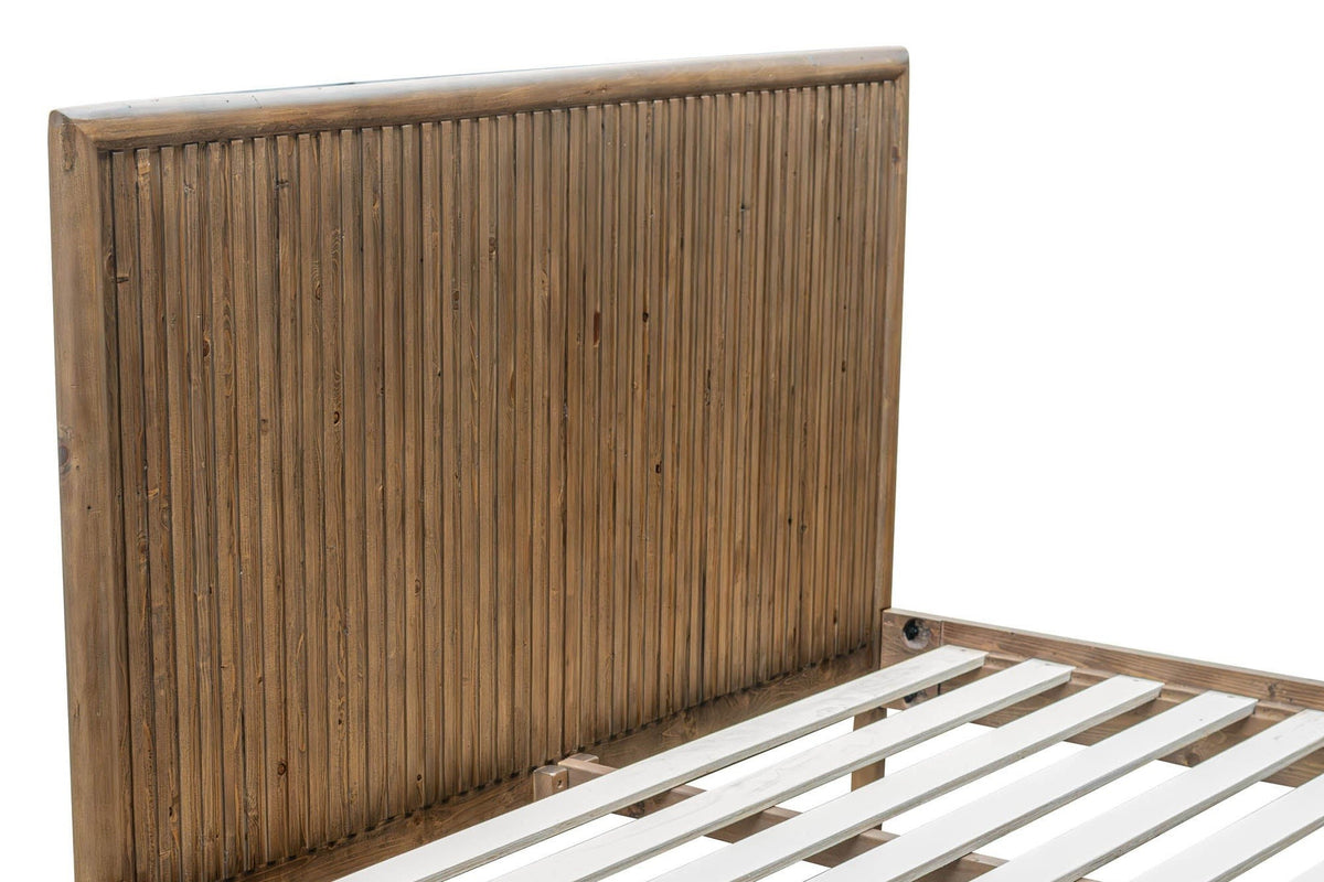 Close-up of the Pettorano headboard: narrow vertical rounded reeds inside a thick round frame, the side rail and slats below