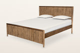 Pettorano bed in Brown reclaimed pine, three-quarter view on a warm white studio backdrop: a tall reeded headboard