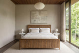 Front view of the Pettorano bed in a bedroom in a Terra Cotta forest house in the Credit River valley, with greige plaster