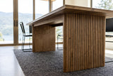 The Pettorano base in Brown at seat height: a reeded slab leg with rounded edges, the plain inner face of the far slab