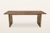 Pettorano dining table in Brown, straight front view on a warm white studio backdrop: a long planked top with a stepped edge
