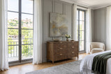 Pettorano dresser in Brown reclaimed pine in a Lyon apartment bedroom, with grey panelled walls, an abstract painting