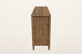Pettorano sideboard in Brown, end view on a warm white studio backdrop: a planked pine end between two round posts on tapered