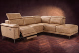 The Pista sectional in Washed Sand distressed full leather on a dark walnut herringbone floor against a brown plaster wall, the seat beside the box arm reclined with its two-tier footrest out and its headrest raised, the other headrests down. Shown in Washed Sand, Right chaise.