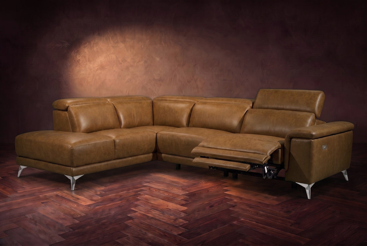The Pista sectional in Weathered Saddle distressed full leather on a dark walnut herringbone floor against a brown plaster wall, the seat beside the box arm reclined with its two-tier footrest out and its headrest raised, the other headrests down. Shown in Weathered Saddle, Left chaise.