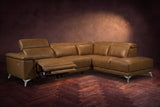 The Pista sectional in Weathered Saddle distressed full leather on a dark walnut herringbone floor against a brown plaster wall, the seat beside the box arm reclined with its two-tier footrest out and its headrest raised, the other headrests down. Shown in Weathered Saddle, Right chaise.
