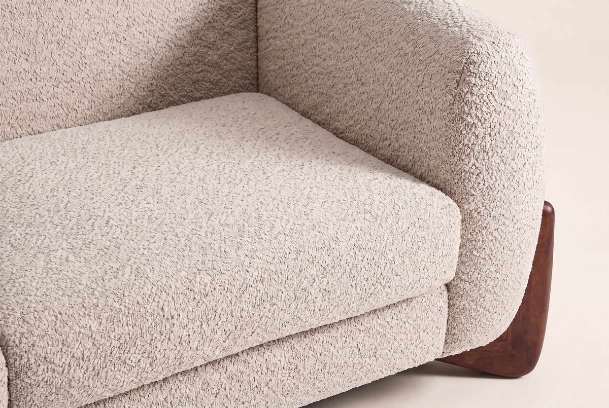 Close-up of the almond boucle seat cushion and the rounded arm