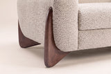 Close-up of a walnut-finish wooden wedge foot at the corner of the boucle arm