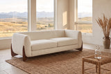 Pistoia sofa in Beige boucle in a sunlit room with the Calgary foothills through tall windows and a jute rug