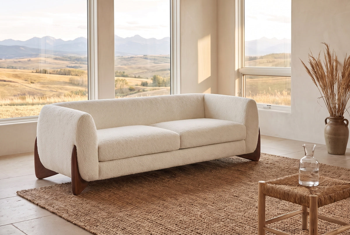 Pistoia sofa in Beige boucle in a sunlit room with the Calgary foothills through tall windows and a jute rug