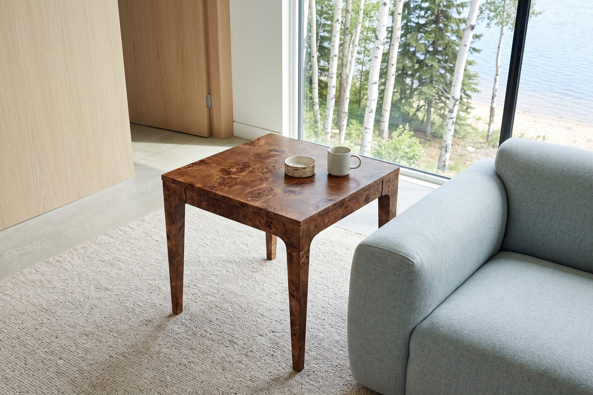 Polcenigo side table in Dark Burl seen from above beside a grey-blue wool sofa in a Candle Lake house
