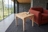 Polcenigo side table in Honey Blonde Burl seen from above beside a rust boucle lounge chair in a Fairmont Hot Springs house